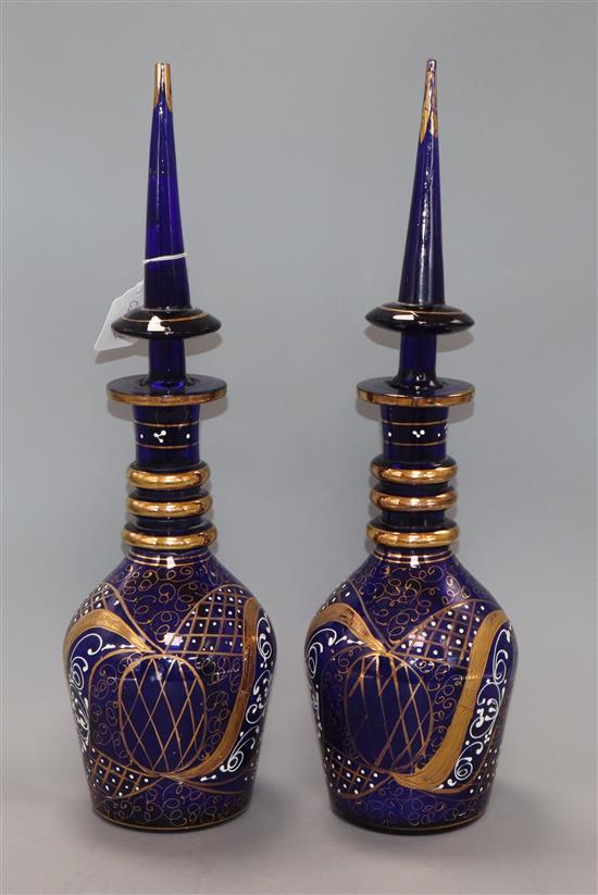 A pair of blue glass decanters with steeple shaped stoppers height 49cm